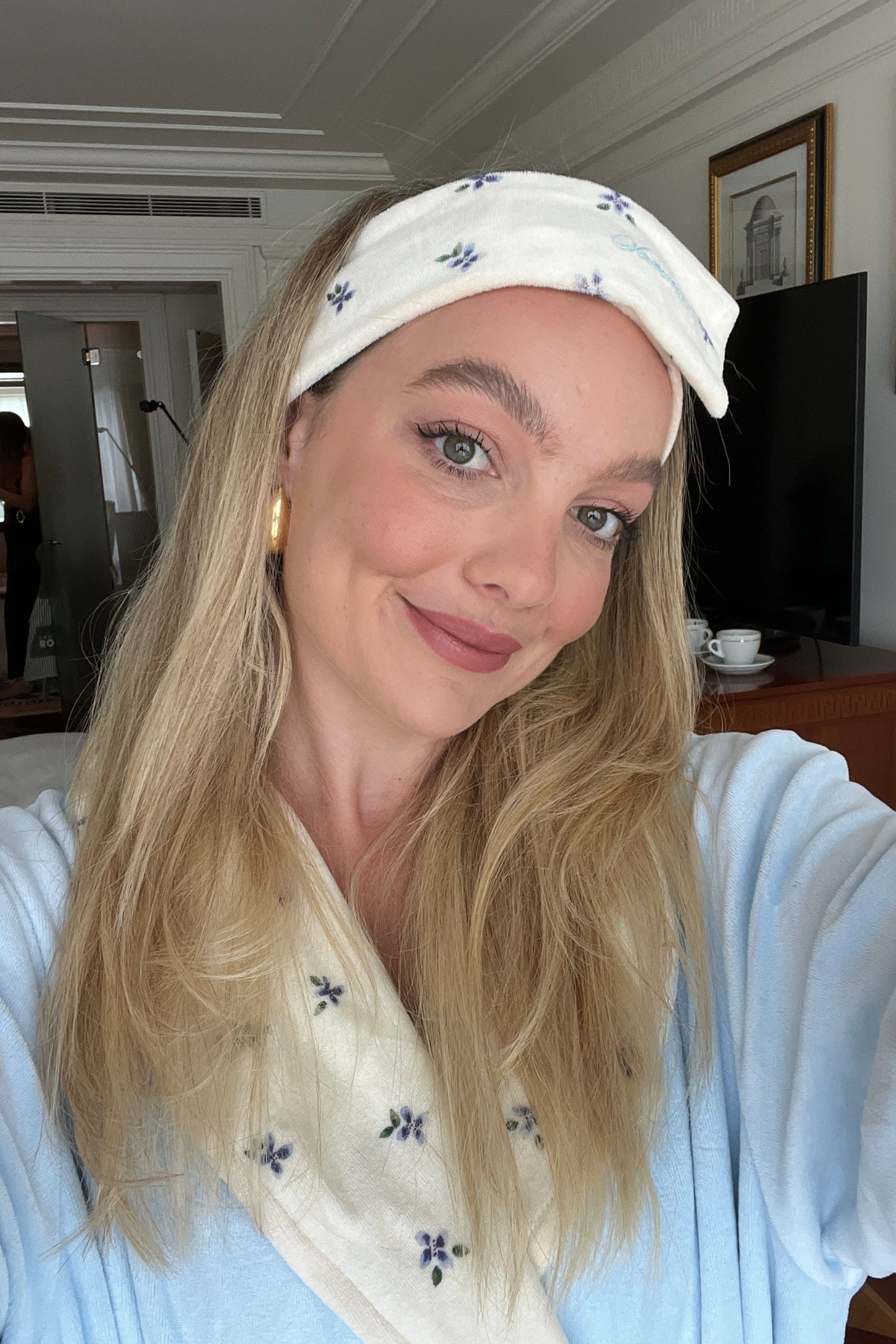 Woman wearing a cream headband with a floral pattern at a hotel.