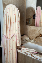 Bathroom with a floral robe hanging up, sink, and mirror.