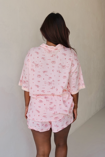 Person wearing a pink floral pajama set against a plain background from the back